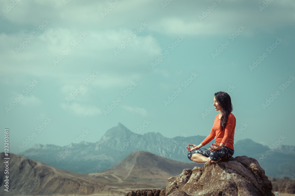 The girl is engaged in yoga on a background of ocean, tree pose