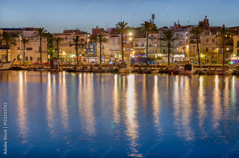 Colorful buildings on the quay of Tarragona port and light reflection in water, Spain