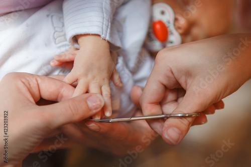   utting newborn baby nails with scissors  