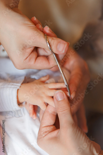 Сutting newborn baby nails with scissors 