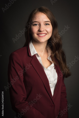 Bewerbungsfoto einer Studentin auf schwarzem Hintergrund - Lächelnde junge Frau im Portrait 