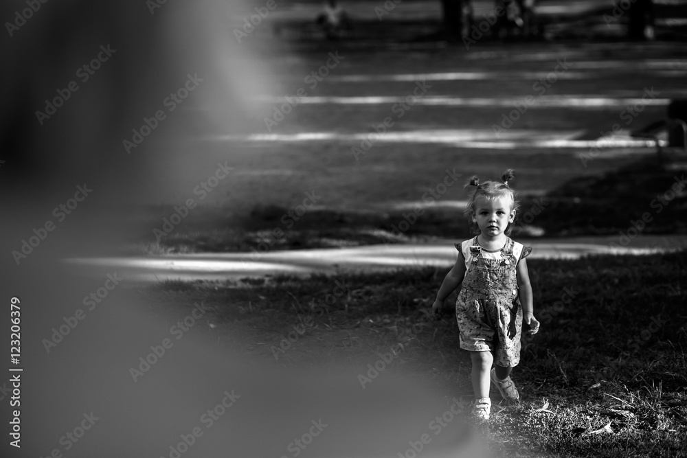 Obraz premium Look from behind mother's shoulder at pretty little girl running