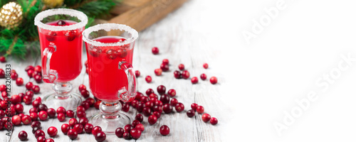 Festive Cranberry drink on Christmas background, white wooden table