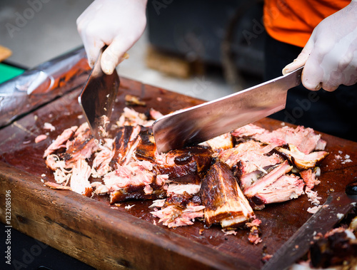 Hands cleaning Grilled spare beef or pork ribs from smoker. photo