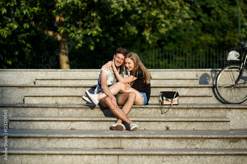 Smiling woman leans to her man while they sit on footsteps cover