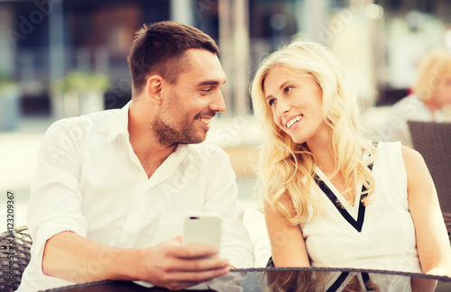 happy couple with smatphone at city street cafe © Syda Productions