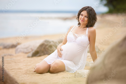 Pregnant woman resting on the beach  