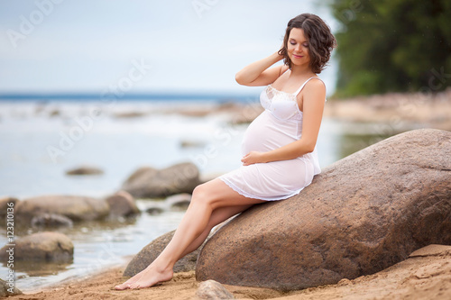 Pregnant woman resting on the beach 