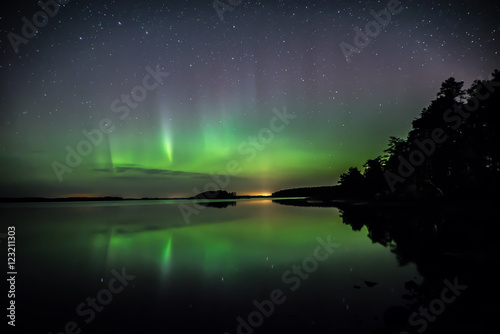 Scenic view of northern lights over calm lake © Conny Sjostrom