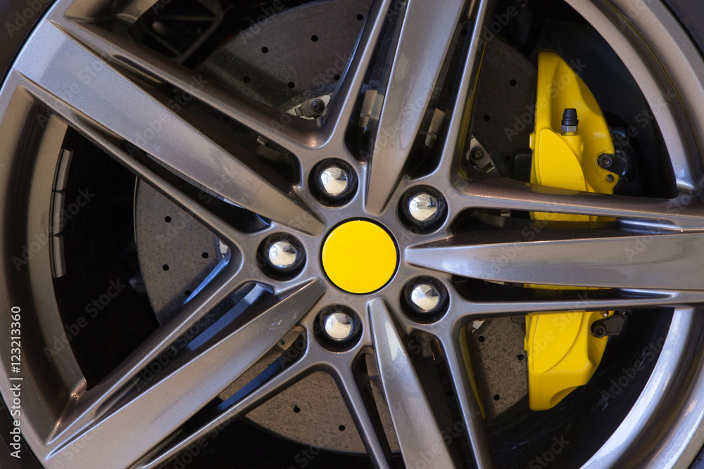 Sports car wheel with carbon ceramic disc and yellow brake caliper
Sports car wheel with carbon ceramic disc and yellow brake caliper