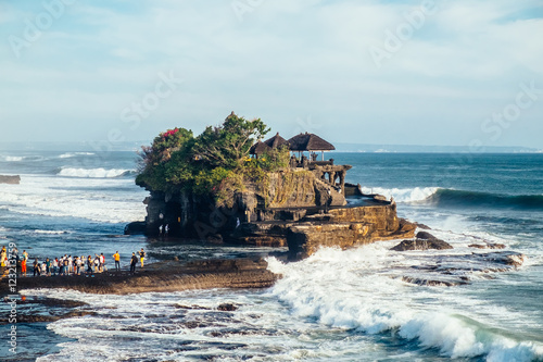 Outdoors sea view near Tanah Lot temple with line of people, Bali. Indonesia nature landscape in sunny daylight