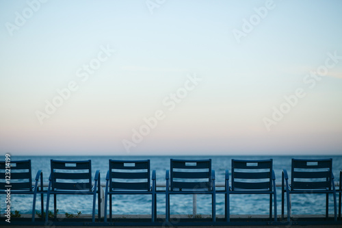 Empty beach chairs stand by blue sea