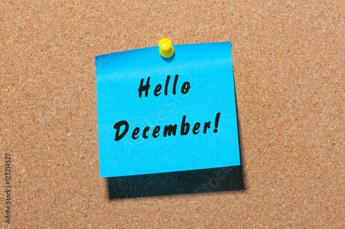Hello December written on blue paper pinned at cork notice board with empty space for text. Eve, Christmas and New year time concept
