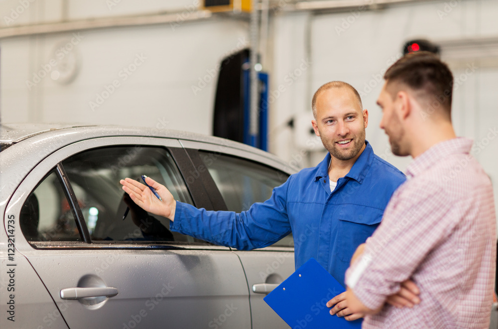auto mechanic with clipboard and man at car shop auto mechanic with clipboard and man at car shop