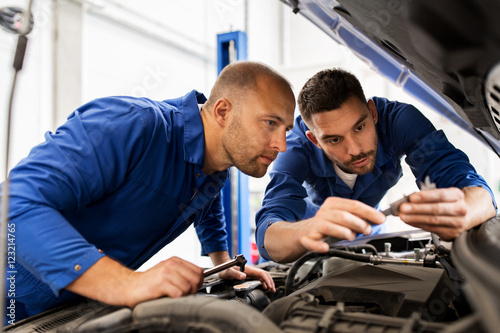 mechanic men with wrench repairing car at workshop