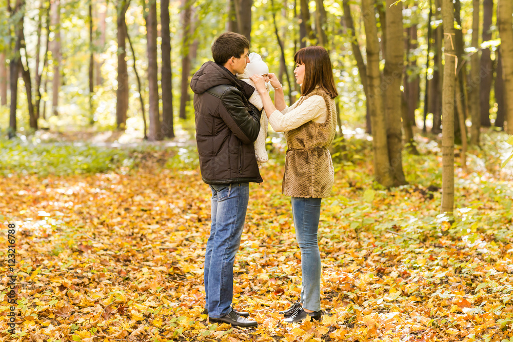love, parenthood, family, season and people concept - smiling couple with newborn baby in autumn park