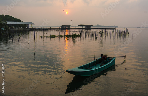 Sunrise and a small fishing boat in the river at Tha Chalaep, Chanthaburi, Thailand.