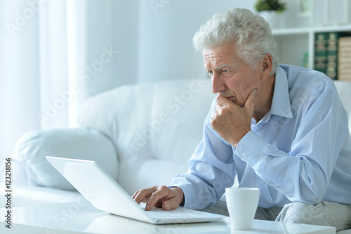 senior man at home with laptop