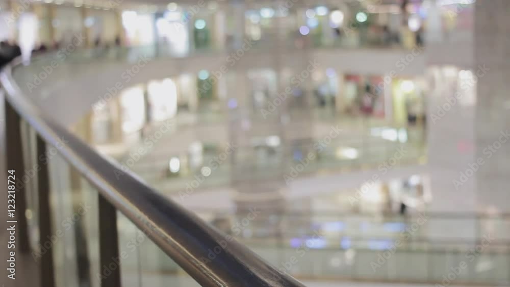 Male hands puts brown paper bag with red SALE sticker on it on handrail in shopping mall close up Male hands puts brown paper bag with red SALE sticker on it on handrail in shopping mall close up