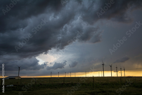 Severe storms threaten near wind turbines at sunset, south of Dumas, Texas photo