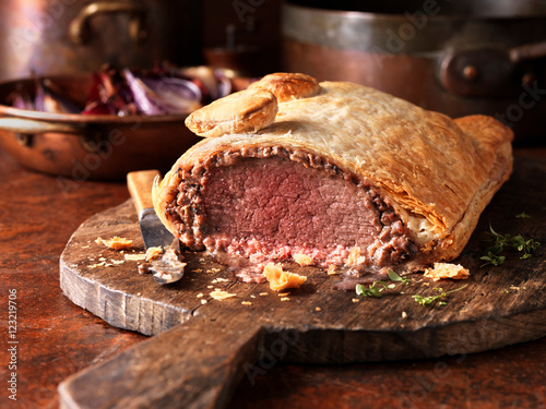 Roast beef wellington, red onions in background, fresh thyme photo