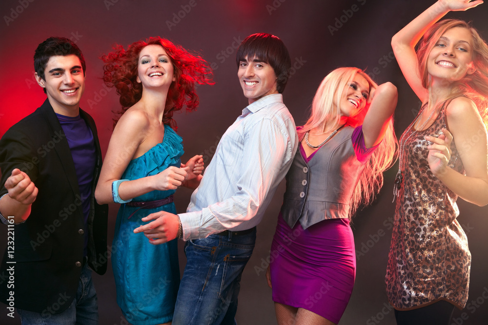 Five people looking at camera and dancing