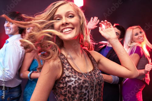 A beautiful girl dancing against her friends