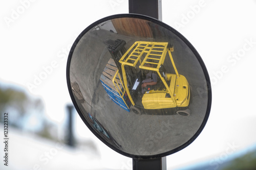 Convex mirror image of forklift driver at packaging factory