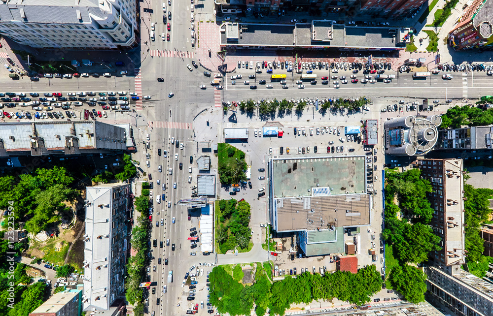 Obraz premium Aerial city view with crossroads and roads, houses, buildings, parks and parking lots, bridges. Urban landscape. Copter shot. Panoramic image.