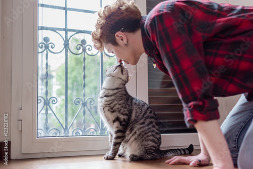 Cute scene between a woman and her european cat indoor in her house - owner, love, affection concept photo