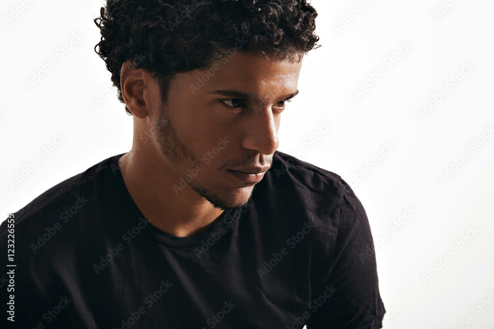 Obraz premium Moody thoughtful black young model wearing a blank black t-shirt isolated on white