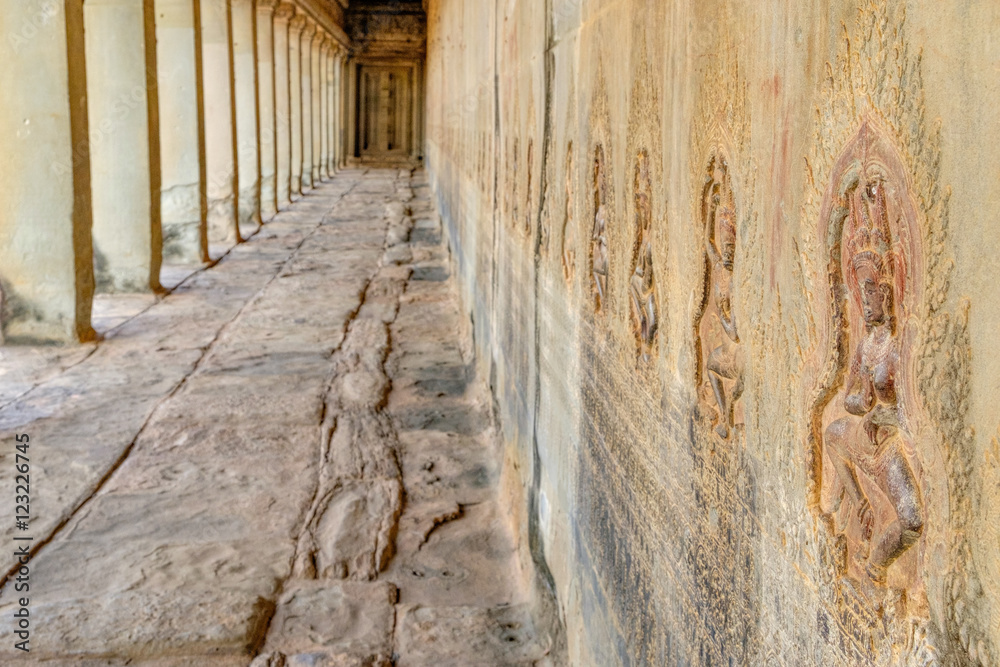 Obraz premium Dancing Apsaras an old Khmer art carvings on the wall in the corridors of Angkor Wat temple near Siem Reap town, Cambodia. Selective focus on nearest bas-relief