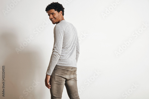 Back view of attractive latino man looking with happy smile in camera turning around, isolated on white, wearing blank heather grey clothing © BublikHaus