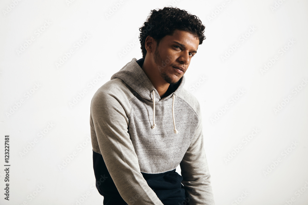 Portrait of attractive young man wearing blank normcore clothes grey seat hoodie seriously looking in camera Portrait of attractive young man wearing blank normcore clothes grey seat hoodie seriously looking in camera