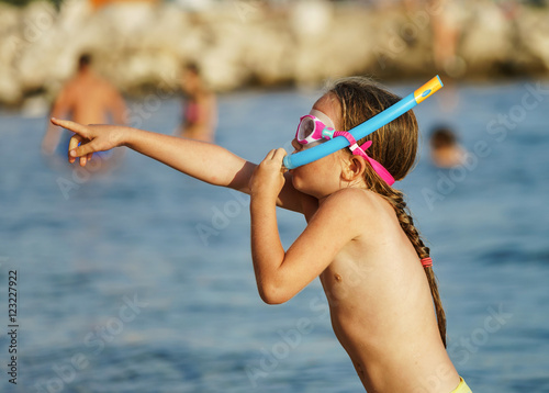 Little girl swimming in the sea with water mask
