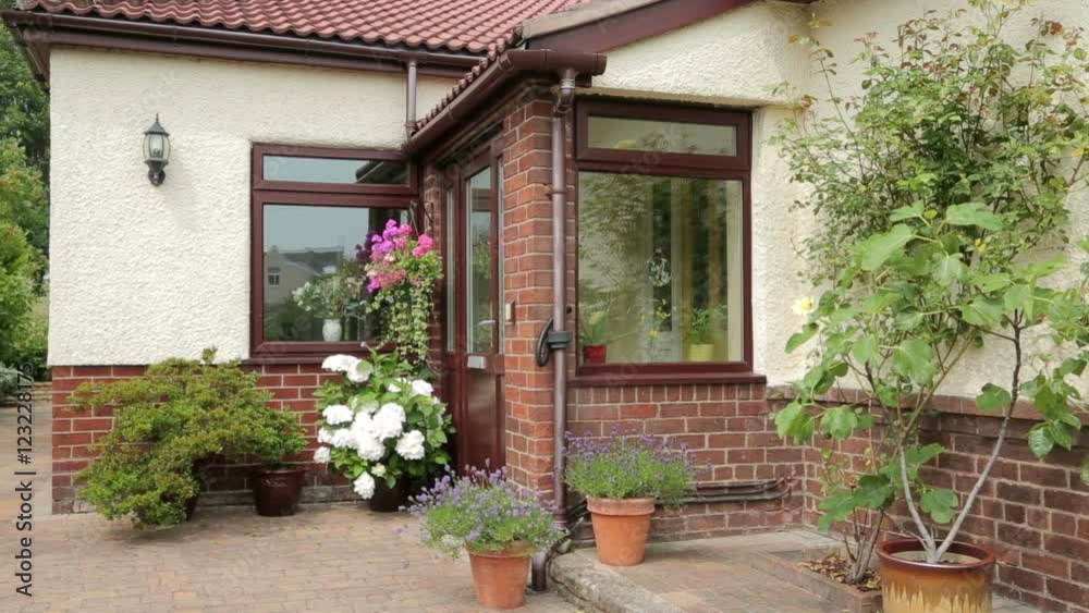 Front door and porch of bungalow with pots and shrubs Front door and porch of bungalow with pots and shrubs