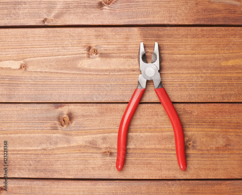 Lineman's combination pliers hand tool on wooden surface