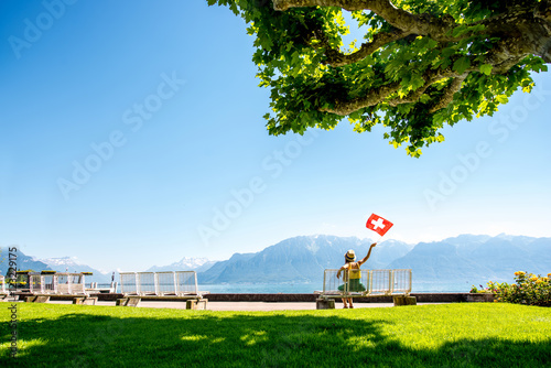 Beautiful landscape view on the park and mountains near Geneva lake with woman sitting on the bench in Switzerland