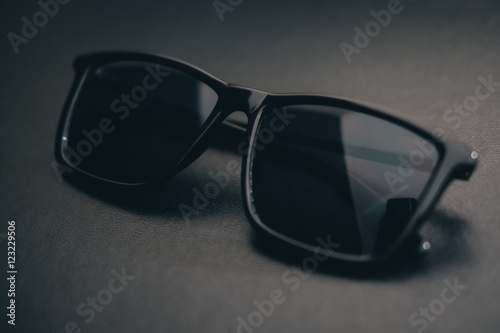Close Up Black Sunglasses on the Black Leather Background