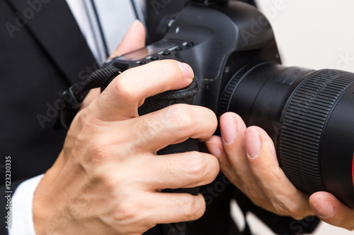 Business man with dslr camera in black suit close up