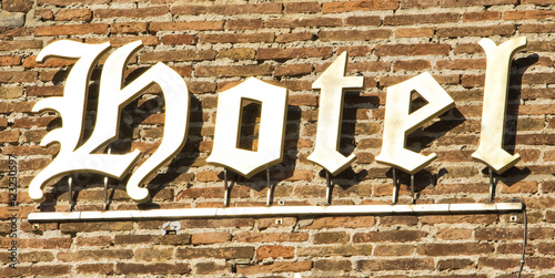  The heraldic characters hotel sign on the brick wall. Florence, Italy. photo