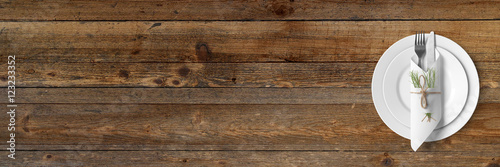 Schlichtes Tischgedeck auf rustikalem Holztisch - Banner / Hintergrund - Textfreiraum 