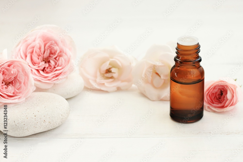 Rose essential oil, fresh pastel colored flowers, spa stones, fragrant cosmetic line. Empty space for product display. Rose essential oil, fresh pastel colored flowers, spa stones, fragrant cosmetic line. Empty space for product display.