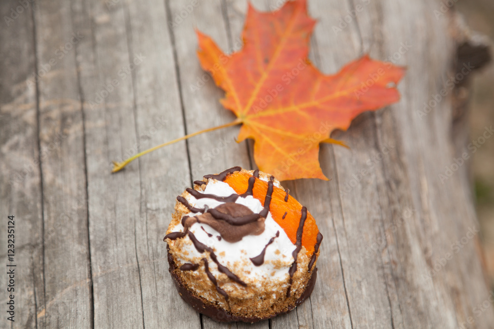 Fototapeta premium sweet cake and autumn yellow maple leaf