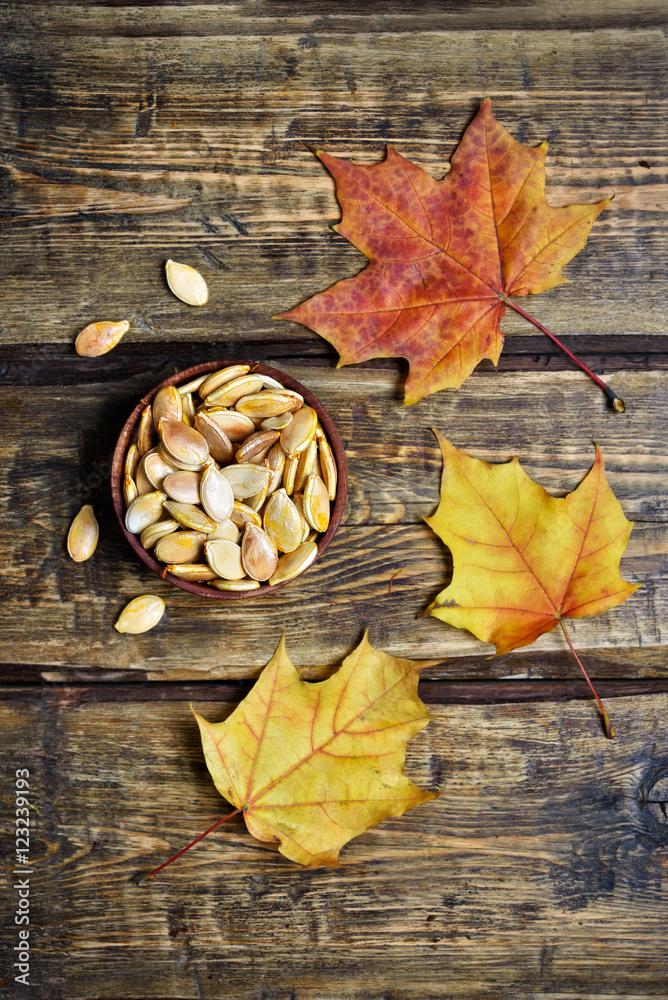 Pumpkin seeds and autumn leaves