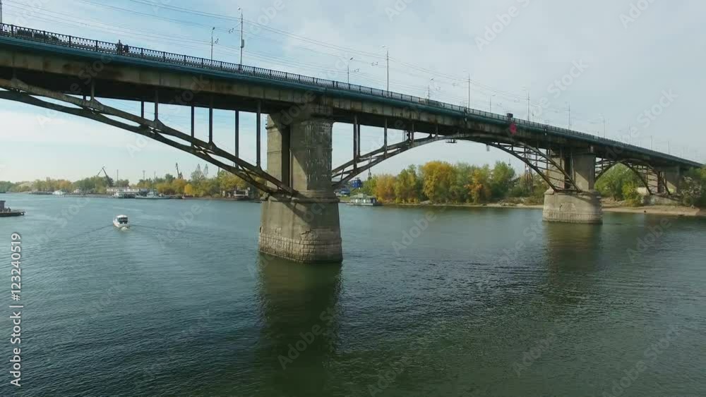 Flying near the bridge at Samara river. Car traffic at bridge and boats floating under the bridge. Drone moving from left to right. 4K Aerial stock footage clip.
Flying near the bridge at Samara river. Car traffic at bridge and boats floating under the bridge. Drone moving from left to right. 4K Aerial stock footage clip.