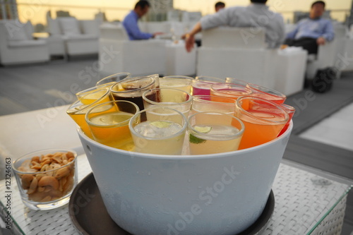 rainbow cocktail shotes serve in ice bucket in evening twilight nature light with background as business men hangout with friends - backlight pic. photo