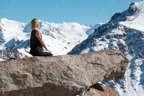 Woman is practicing yoga against Kazakhstan mountains.
