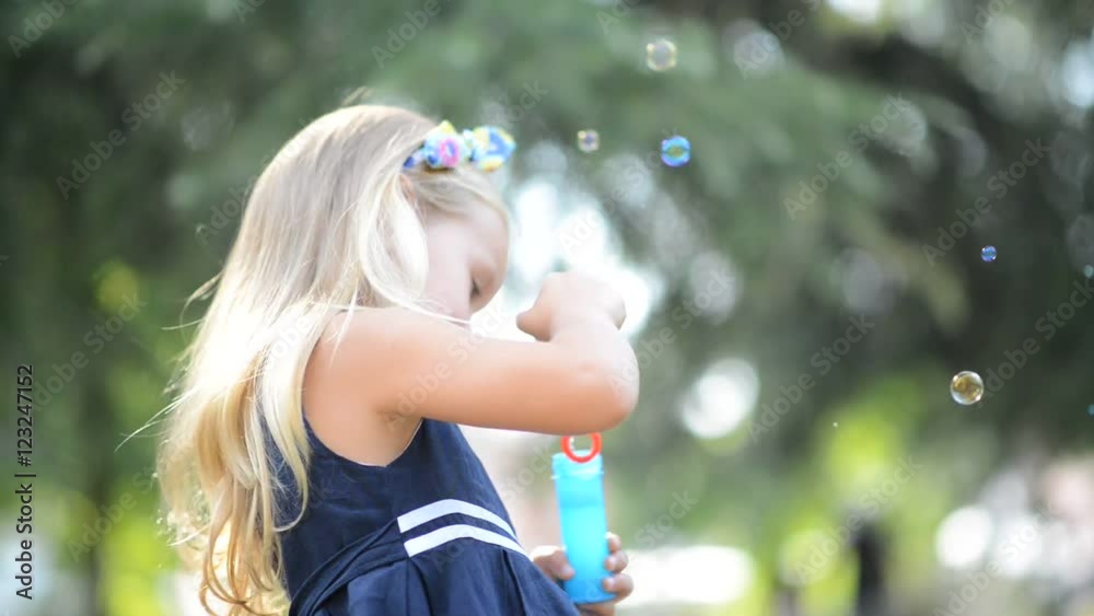 Children girl blowing soap bubbles in outdoor forest Children girl blowing soap bubbles in outdoor forest