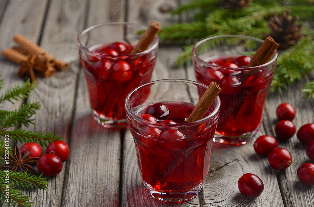 Cranberry drink on wooden background with fir branches and fresh berries, selective focus Cranberry drink on wooden background with fir branches and fresh berries, selective focus